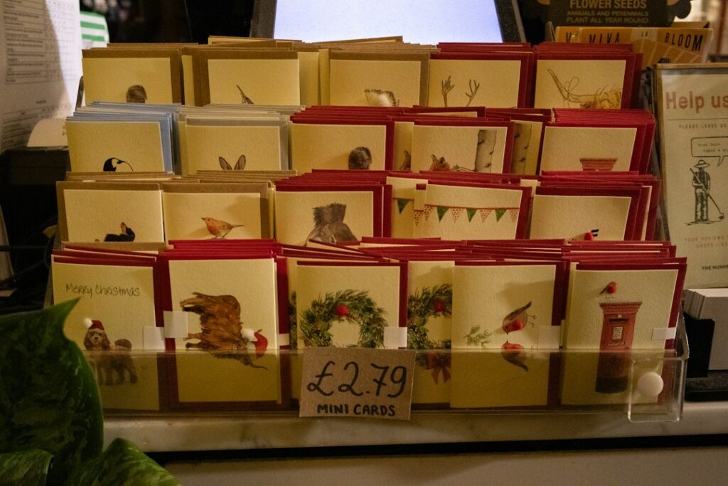 A shop display of small greeting cards printed with a variety of illustrated artwork designs