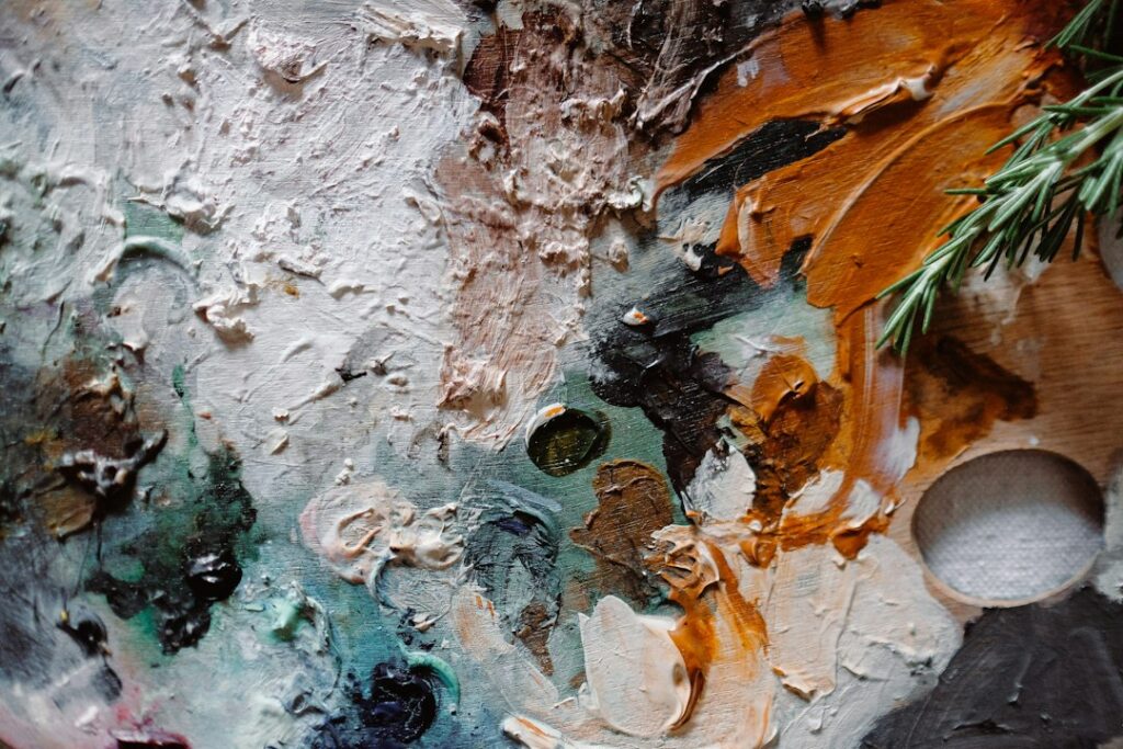 Close up of thick, colourful oil paint on a canvas in an artist's studio