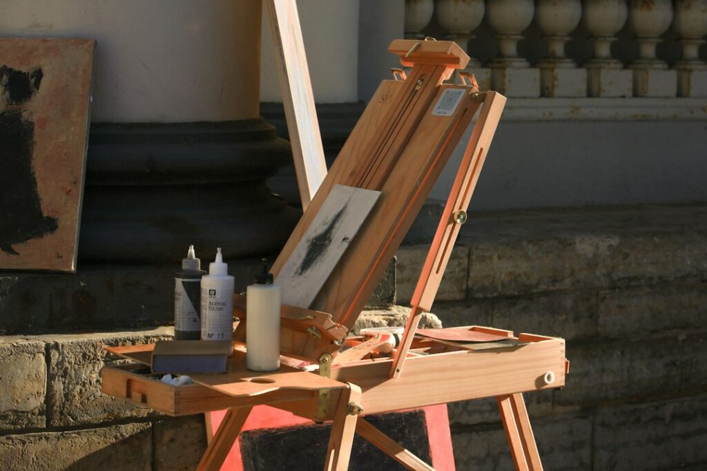 A painting in progress resting on a wooden easel in an artist's studio