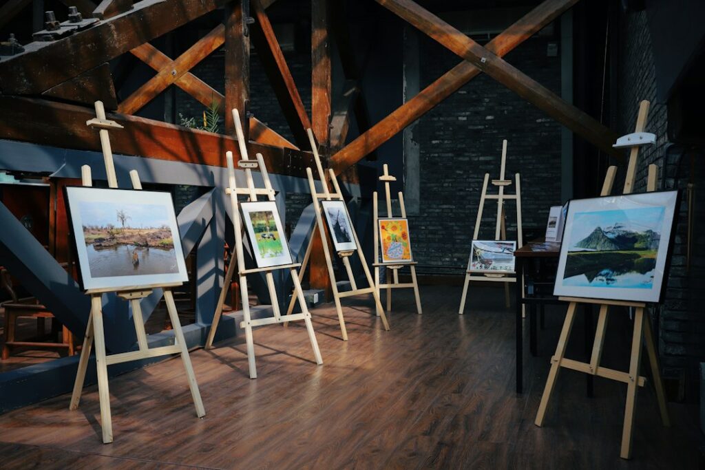 Five paintings displayed together on easels in an artist's studio, forming a small body of work