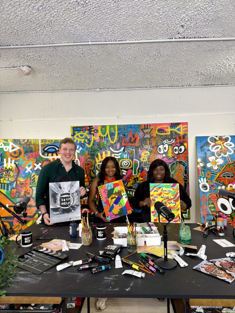 James Carter at an art workshop surrounded by colourful paintings