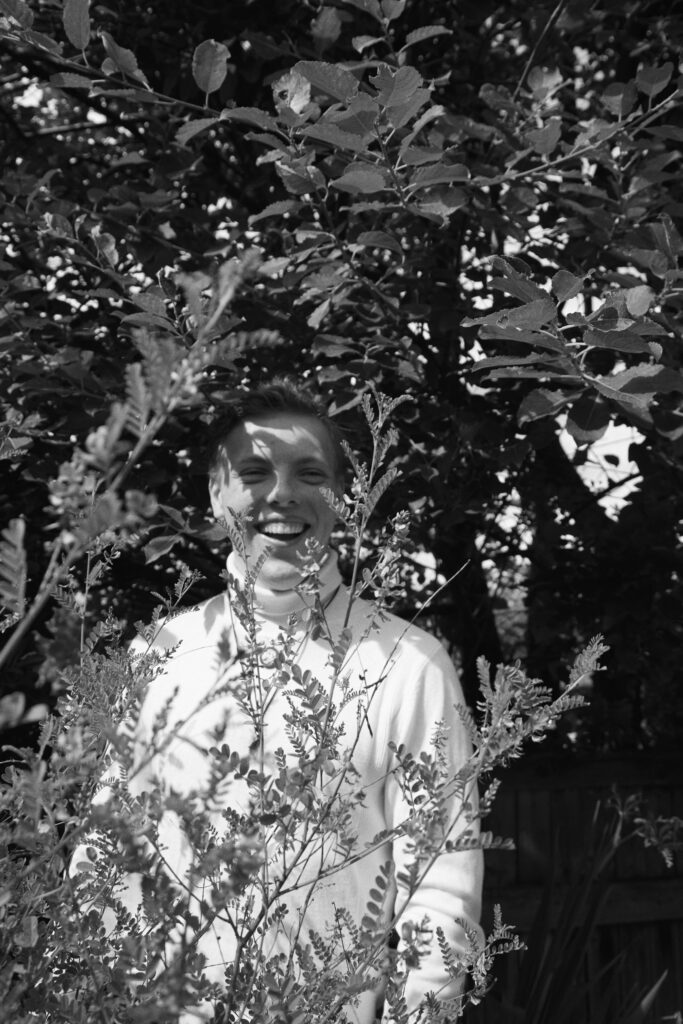 Black and white portrait of James Carter framed by leaves