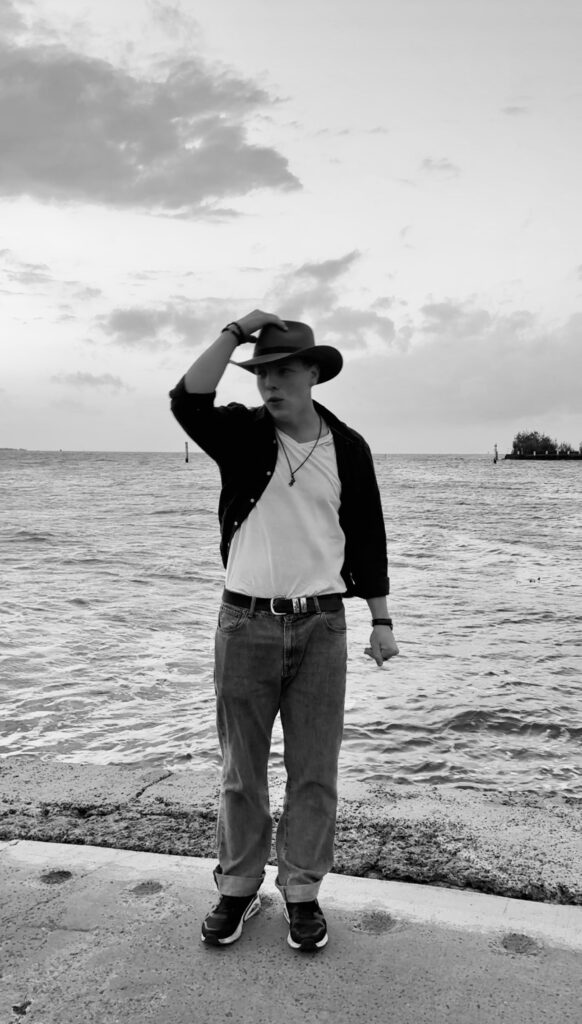 Black and white seaside portrait of James Carter in a hat