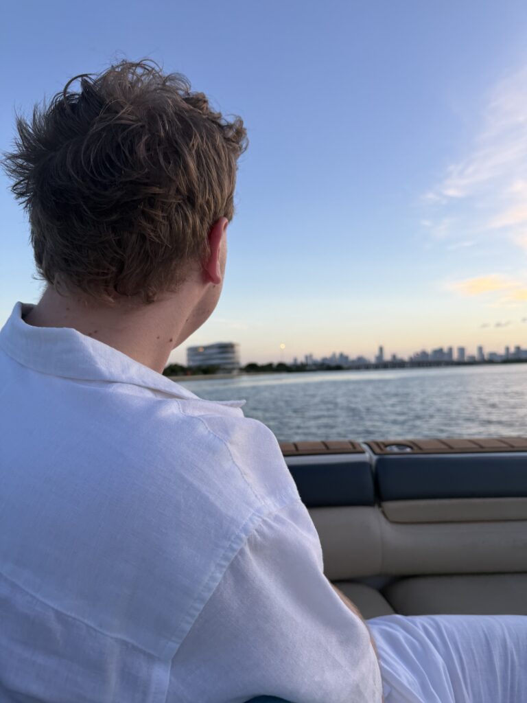 James Carter on a boat at sunset with the Miami skyline behind