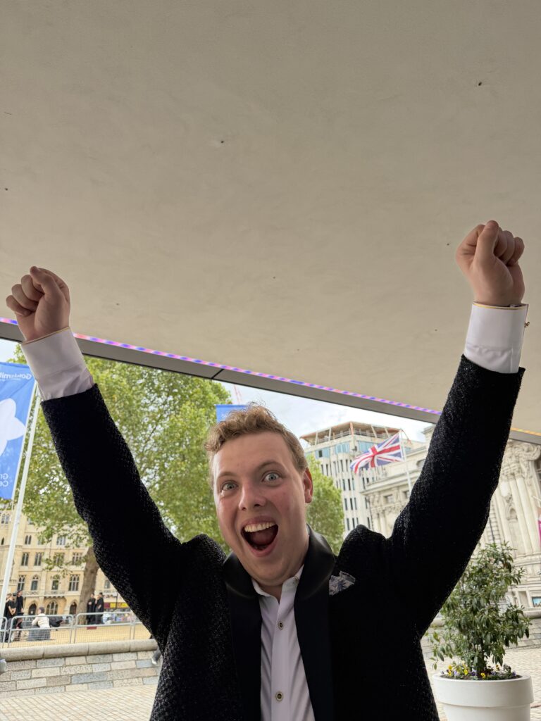 James Carter celebrating his graduation with arms raised