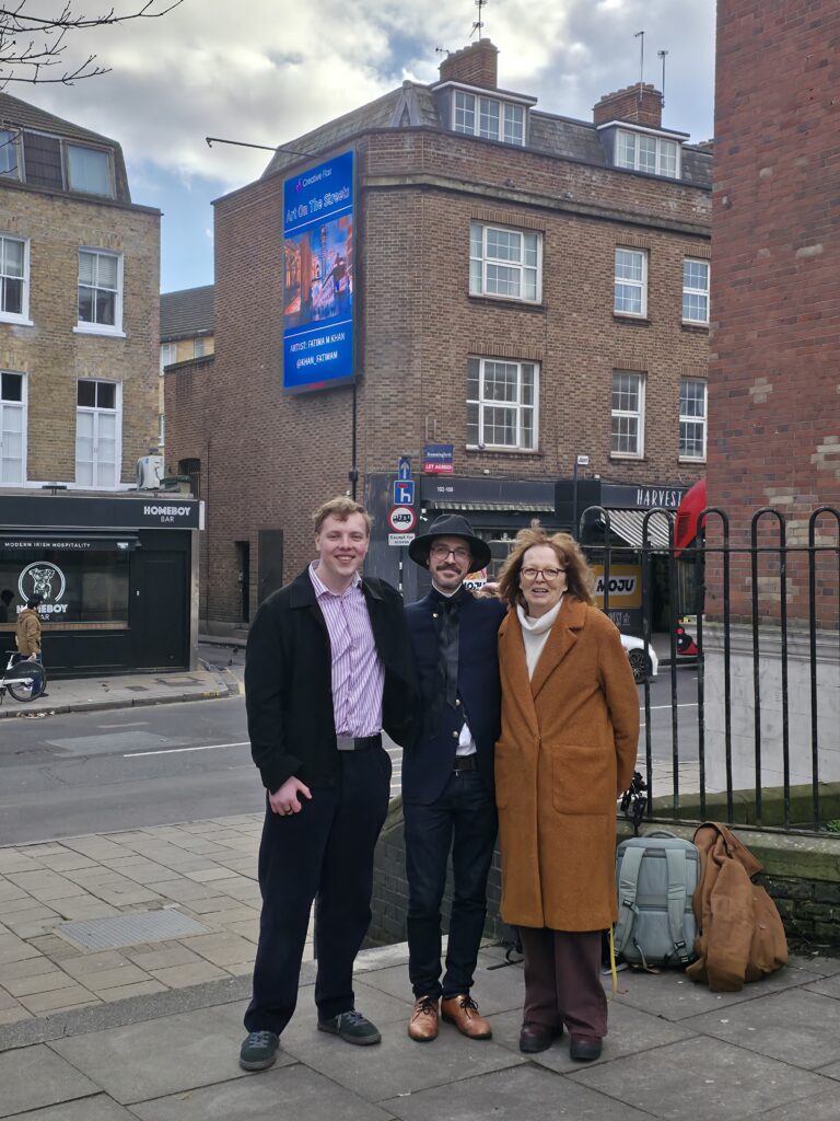 James Carter in front of a Creative Flair Art on the Streets billboard in Islington, London