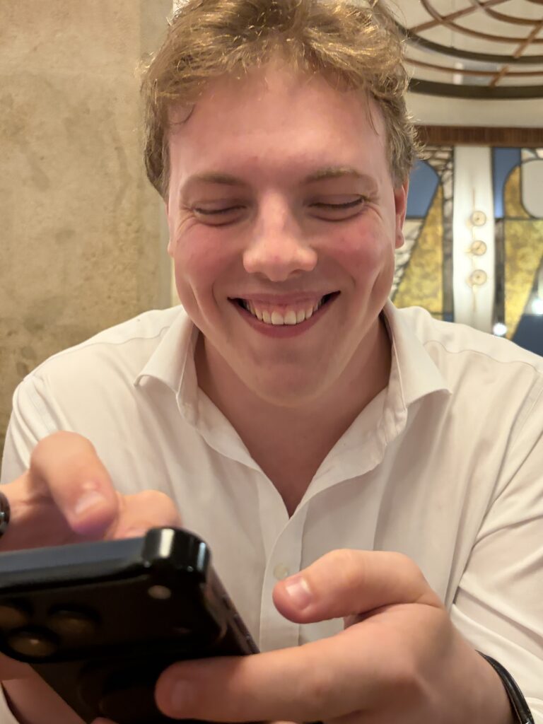 James Carter laughing at his phone in Vienna