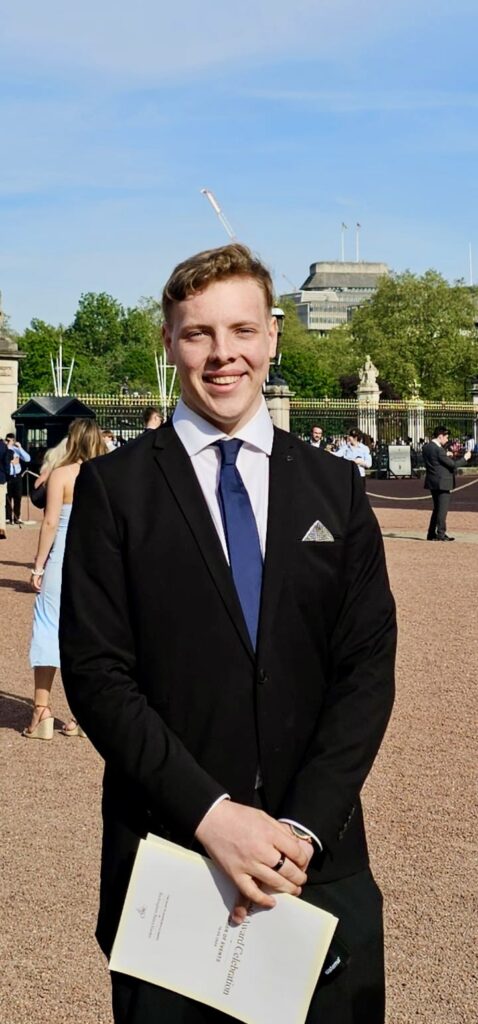 James Carter in a navy suit at Buckingham Palace