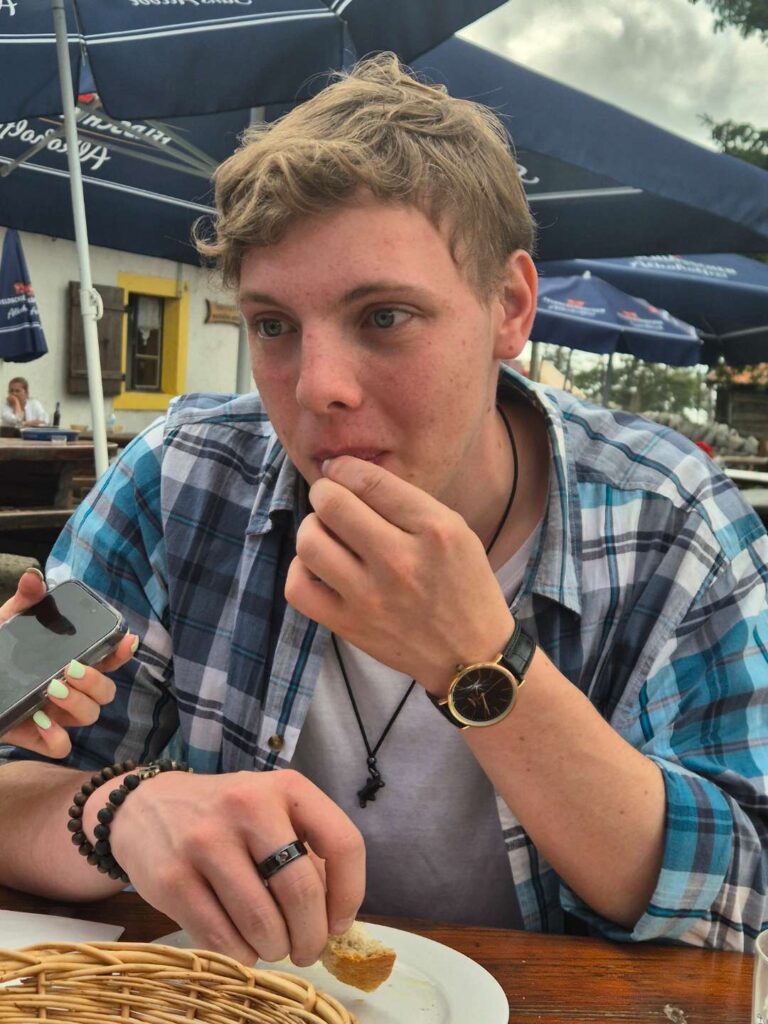 James Carter in a plaid shirt at lunch at an outdoor cafe