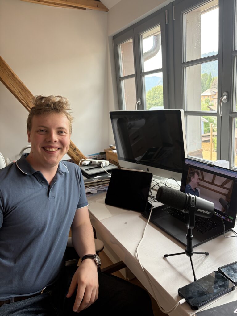 James Carter at his podcast desk in Switzerland