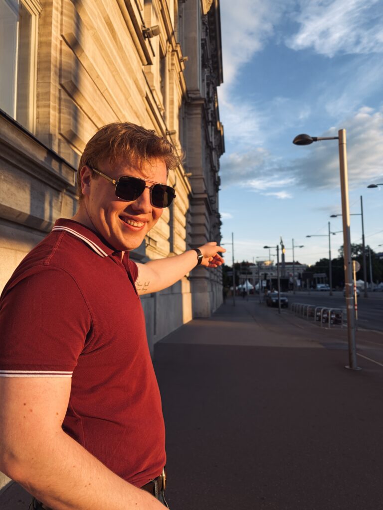 James Carter pointing at the sunset on a street in Vienna