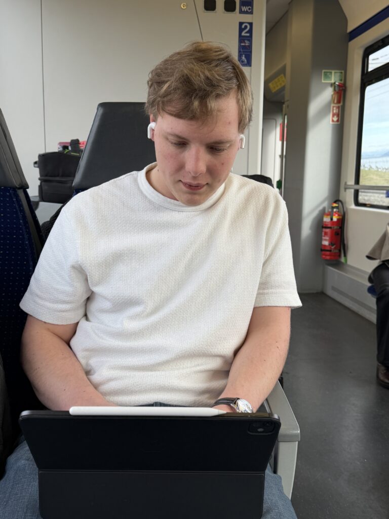 James Carter working on an iPad on a train