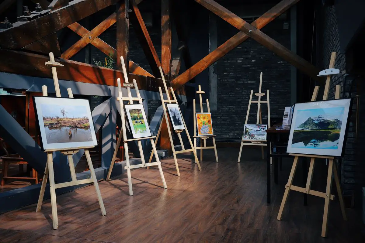 Image description: A person standing in front of a contemporary art gallery, with vibrant and diverse artworks displayed on the walls.